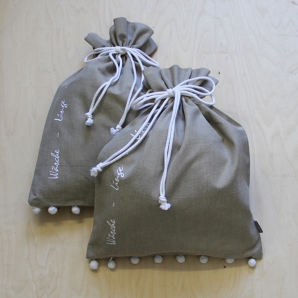 Bild von Wäschesack beige mit Pompons